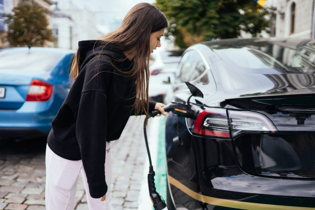 EV driver connecting car to smart charger from CITA in residential area.